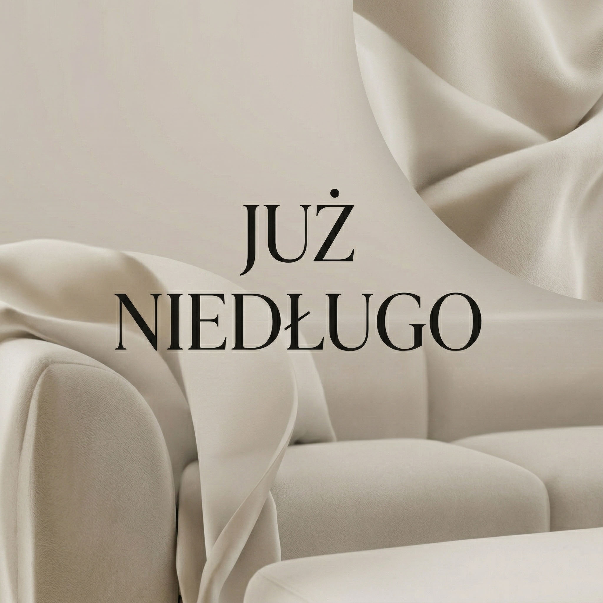 Beżowy welurowy drapowany materiał z napisem "JUŻ NIEDŁUGO" na górze, zapowiadający nową kategorię sof.